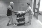  ??  ?? Patient care technician Matt Phillips and nurse practition­er Sydney Gressel wheel in dinner boxes delivered by Nightbird Restaurant chef and owner Kim Alter at Benioff Children’s Hospital in San Francisco.