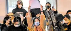  ?? —AFP ?? CENSORED A woman protesting censorship waves a blank paper while at a demonstrat­ion in Shanghai on Sunday.