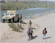  ?? /American-Statesman/USA Today ?? Migrant issues: A group of migrants from Venezuela walk along the banks of the Rio Grande.