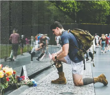  ?? MICHAEL A. MCCOY/REUTERS ?? Members of the United States military, veterans and members of the public visit the Vietnam Veterans Memorial while commemorat­ing the U.S. Memorial Day holiday in Washington on Monday.