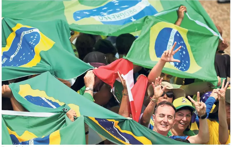  ??  ?? New populist chapter: Bolsonaro supporters gathering for the inaugurati­on ceremony of the far-right president at ‘ Tres Poderes’ square in Brasilia. —