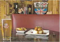  ?? DAVE SIDAWAY, MONTREAL GAZETTE FILES ?? The menu at the Burgundy Lion includes such British mainstays as Scotch eggs (centre) or bangers and mash (at right), washed down with a beer.