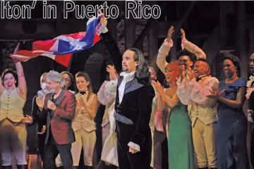  ??  ?? Lin Manuel Miranda, centre, raises the Puerto Rican flag after the sold-out opening-night performanc­e of the award-winning Broadway musical “Hamilton” in San Juan, Puerto Rico. — Photos by Dennis M. Rivera Pichardo for The Washington Post