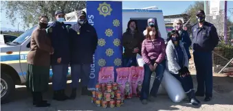  ??  ?? Lede verbonde aan die Oudtshoorn-polisie oorhandig die kos wat hulle gekoop het aan Odin. Foto: Liezl van Niekerk