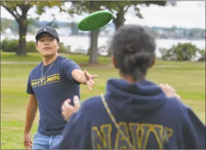  ??  ?? Norwalk’s Dyago Cordero and Aileen Perez throw the frisbee around during the event.