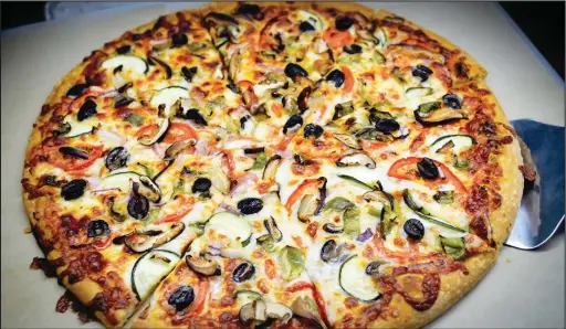  ?? SEAN LAUGHLIN/NORTHWEST ARKANSAS DEMOCRATGAZETTE ?? A la Carte has two types of pizza each day, a meat pizza and one with only veggies. They also make pizza on request.