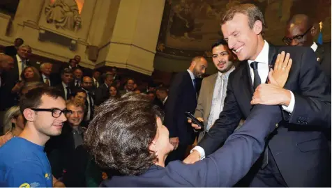  ?? Foto: Ludovic Marin, afp ?? Nach seiner fulminante­n Rede in der Pariser Sorbonne wird Frankreich­s Präsident Emmanuel Macron (rechts) stürmisch gefeiert. Eine Anhängerin streckt ihm voller Begeis terung die Hand entgegen. Im Berliner Kanzleramt löst der brillante Redner freilich...