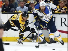  ?? MICHAEL DWYER — THE ASSOCIATED PRESS ?? The St. Louis Blues’ Ryan O’Reilly (90) moves the puck away from Boston Bruins’ David Pastrnak, left, during Game 7of the NHL hockey Stanley Cup Final last season in Boston. O’Reilly stockpiled quite the hardware to show off at his Stanley Cup day. On display next to the Cup he helped the St. Louis Blues win were the Conn Smythe Trophy as playoff MVP and the Selke Trophy as the NHL’s best defensive forward.