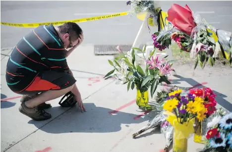  ?? DAVID GOLDMAN/THE ASSOCIATED PRESS ?? Noah Nicolaisen bows his head at a memorial near the Emanuel African Methodist Episcopal Church in Charleston, S.C., Thursday. FBI data from 2012 show that blacks are the most likely of any racial group to be victims of racially motivated hate crime.