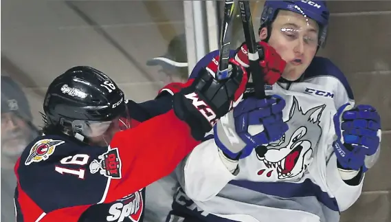  ?? DAN JANISSE ?? Chris Playfair, left, of the Spitfires gets in the face of Zack Malik of the Sudbury Wolves during their game on Thursday night at the WFCU Centre.