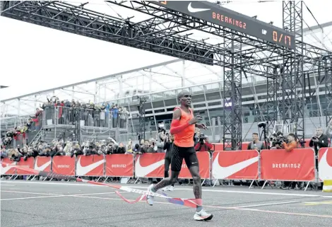  ?? LUCA BRUNO/AP FILES ?? Olympic marathon champion Eliud Kipchoge crosses the finish line of a marathon race at the Monza Formula One racetrack in Italy. Kipchoge was 26 seconds from making history on May 6.