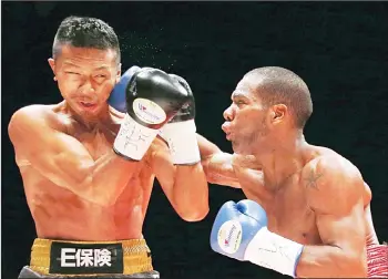  ?? (AP) ?? Panama’s Jezreel Corrales (right), sends a right to Japanese champion Takashi Uchiyama in the first round of their WBA world super featherwei­ght boxing title match in Tokyo on April 27. Corrales won the world title with a knockout in the second round.