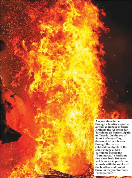  ??  ?? A man rides a horse through a bonfire as part of a ritual in honour of Saint Anthony the Abbot in San Bartolome de Pinares, Spain on Tuesda. On the eve of Saint Anthony’s Day, dozens ride their horses through the narrow cobbleston­e streets of the small...