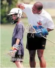  ?? STEVE MCKINLEY HAMILTON SPECTATOR FILE PHOTO ?? Brendan MacLean of a U-13 team waits patiently while guest coach Roger Nurse tests out his new lacrosse helmt during 1998 practice.