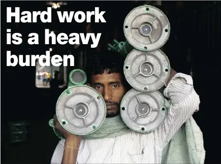  ?? PICTURE: REUTERS ?? PUMPING IRON: A labourer carries iron hand pumps through an alley at a wholesale market in Kolkata, India. Men in physically taxing jobs may be at risk of an early death, a study has found.