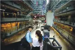  ??  ?? BEIJING: People ride an escalator at an upscale shopping mall in Beijing on Tuesday. China’s trade growth weakened in July in a negative sign for growth in the world’s second-largest economy and global demand. —AP