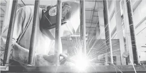  ?? — WP-Bloomberg photo ?? An employee welds a steel part in the metal fabricatio­n area at the Everglades Boats manufactur­ing facility in Edgewater, Florida, in January. New Labor Department figures show employers added more workers in February than projected but wages...