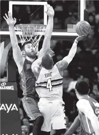  ??  ?? Nuggets guard Randy Foye gets his shot blocked by Detroit Pistons center Aron Baynes on Saturday night at the Pepsi Center. David Zalubowski, The Associated Press