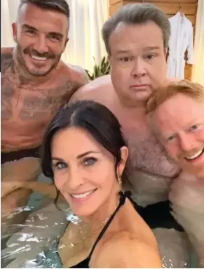  ??  ?? Immersed: Courteney Cox puts a hand on David Beckham’s thigh in hot tub with Eric Stonestree­t, second right, and Jesse Tyler Ferguson