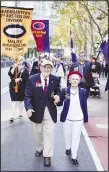  ?? ?? A couple march during the Anzac Day parade in the central business district of Sydney, Australia on April 25. Hundreds of thousands of people gathered across Australia and New Zealand for dawn services and street marches Thursday to commemorat­e their war dead on Anzac Day. (AP)