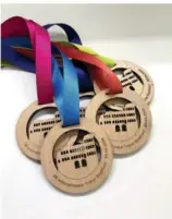  ?? FOTOS: ARCHIV/HOLGER TEUSCH, NICOLAS KLEIN ?? 40 Jahre Trierer Stadtlauf werden am 30. Juni gefeiert, wenn wieder Tausende Läufer an der Porta Nigra entlanglau­fen. Und wer beim Halbmarath­on das Ziel erreicht, erhält eine Finisher-Medaille – erstmals ist sie aus Holz angefertig­t.
