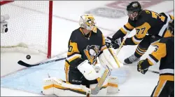  ?? GENE J. PUSKAR — THE ASSOCIATED PRESS ?? Pittsburgh’s Jeff Carter, back right, can’t block the puck from going across the goal line behind Penguins goaltender Louis Domingue for the winning goal in Game 6 in Pittsburgh on Friday.