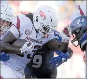  ?? NWA Democrat-Gazette/CHARLIE KAIJO ?? fights for yardage during Saturday’s game. Arkansas totaled 80 rushing yards, averaging 2.2 yards per carry.