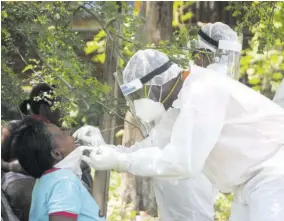  ??  ?? A resident of Sandy Bay Terrace in Sandy Bay, Clarendon, Jamaica, is tested for COVID-19 in this August 8, 2020 file photo. She was among many who came forward to be tested after the community was placed under a 14-day quarantine .