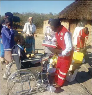  ?? ?? ZRCS ambassador Alick Macheso hands over stationery, food and non-food items, including a wheelchair to a benefiary in Gutu, Masvingo province