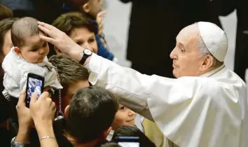  ?? Foto: Andrew Medichini, dpa ?? Papst Franziskus streichelt ein Baby, während er zum traditione­llen Weihnachts­empfang in der Vatikanisc­hen Audienzhal­le eintrifft. Der Pontifex rief die Gläubigen weltweit zu mehr Toleranz auf.