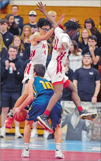  ?? SEAN D. ELLIOT/THE DAY ?? NFA’s Mason Jackson (4) and Kenyatta Peake go airborne defending Woodstock Academy’s Cole Hackett (10) during Saturday’s ECC Division I boys’ basketball tournament semifinal game at Waterford High School’s Francis X. Sweeney Field House. The third-seeded Wildcats cruised to a 63-42 victory and will play top-seeded and defending champion Waterford in Tuesday’s final at Mohegan Sun Arena.