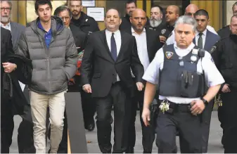  ?? Timothy A. Clary / AFP / Getty Images ?? Movie producer Harvey Weinstein (center) departs a Manhattan Supreme Court after a hearing. More than 80 women have accused him of sexual assault or harassment.