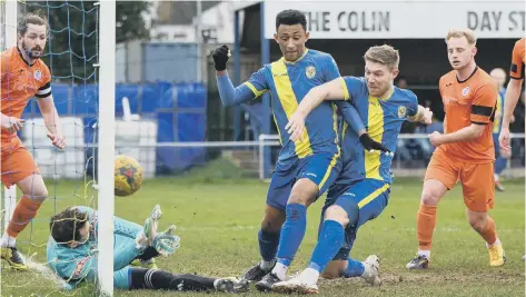  ??  ?? Mark Jones (right, blue) opens the scoring for Peterborou­gh Sports against St Ives. Photo: James Richardson