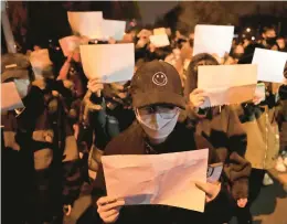  ?? NG HAN GUAN/AP ?? Protesters hold up blank sheets of paper, a symbol of defiance against China’s censorship, on Sunday in Beijing.