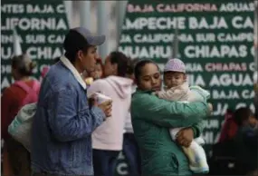  ?? AP PHOTO/GREGORY BULL ?? People seeking asylum in the United States wait Tuesday to receive a number at the border in Tijuana, Mexico. The first obstacle that migrants in a giant caravan may face if they reach the US border is a long wait in Mexico. To enter through San Diego, the wait in Mexico is a month or longer.