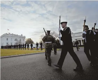  ?? AP PHOTOS ?? REVIEW PREVIEW: Honor guards from the different U.S. armed forces, above, march in a rehearsal of Friday’s Inaugurati­on Day parade in Washington. At right, the presidenti­al viewing stand in front of the White House.