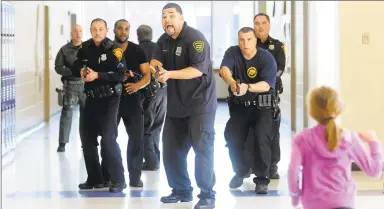  ?? Hearst Connecticu­t Media file photo ?? James Spodnik, a security officer at Fairchild-Wheeler High School, is in the point position during active-shooter training in 2014 at Cesar Batalla School in Bridgeport. In the post-coronaviru­s world, pandemic drills may become a regular part of school life like active-shooter and shelter-in-place drills.