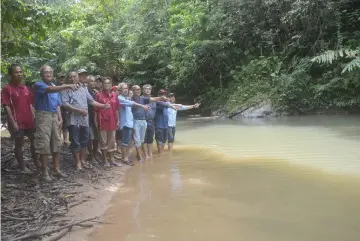  ??  ?? Gluma (right), Jamit (second right) and others point to one of the pools that is an ideal spot to release ‘Semah’ fish fry.