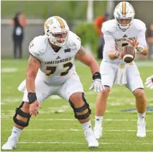  ?? STAFF PHOTO BY ROBIN RUDD ?? UTC quarterbac­k Nick Tiano takes a snap from center Josh Cardiello in the season opener against Jacksonvil­le State. Cardiello is new at the position on an offensive line with only one other starter back from 2016.