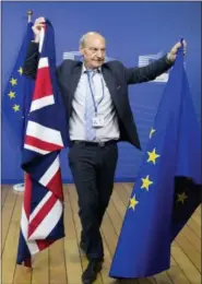  ?? VIRGINIA MAYO — THE ASSOCIATED PRESS FILE ?? A member of protocol changes the EU and British flags prior to the arrival of EU Chief Brexit Negotiator Michel Barnier and British Secretary of State David Davis at EU headquarte­rs in Brussels. Thursday marks 365 days until Britain leaves the European...