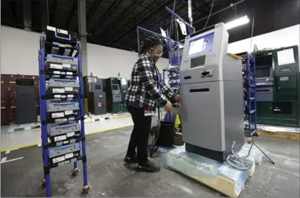  ?? GERRY BROOME, THE ASSOCIATED PRESS ?? Bendu Charles stages an automated teller machine during the manufactur­ing process at the Diebold Nixdorf plant in Greensboro, N.C.