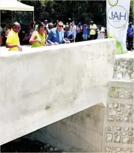  ?? JIS ?? Prime Minister Andrew Holness (right) views the newly rehabilita­ted Georges River Bridge in East Rural St Andrew. Also looking on are: Member of Parliament for the constituen­cy, Juliet Holness (centre), and National Works Agency (NWA) Communicat­ion and Customer Services Manager, Stephen Shaw. Holness officially reopened the bridge during a ceremony yesterday.