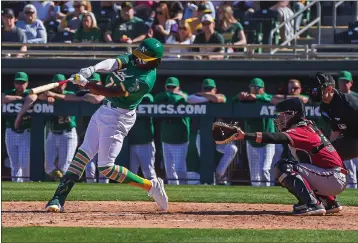  ?? COURTESY OF THE OAKLAND ATHLETICS ?? A’s prospect Lawrence Butler rips a two-run double that capped a six-run fifth inning as the A’s beat the Diamondbac­ks 12-7in the spring training opener for both teams Saturday in Mesa, Ariz.