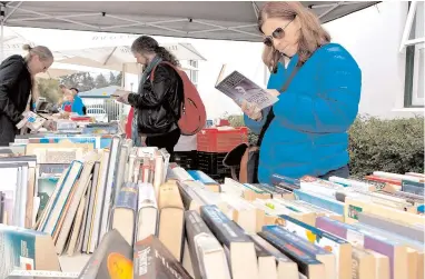  ?? PICTURE: CHE OVERMEYER ?? FAST READERS: Visitors browse through books on display at Franschhoe­k’s annual literary event.