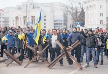  ?? OLEXANDR CHORNYI/AP ?? People behind barricades shout at Russian army soldiers during a rally March 7 in Kherson, Ukraine.