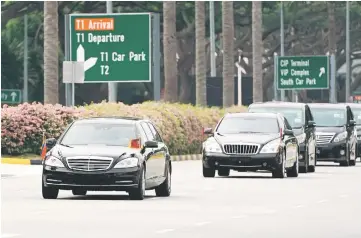  ??  ?? A motorcade believed to be carrying Kim Jong Un travels past in Singapore.