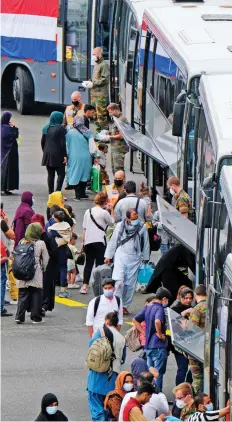  ?? — AFP ?? Passengers embark onto buses upon the arrival of a chartered Air Belgium airplane Airbus A340 carrying evacuated people from Afghanista­n, at the military airport in Melsbroek, on Thursday.