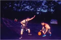  ??  ?? Jones, left, and Rider play a game of one-on-one basketball as night falls at Champ House.