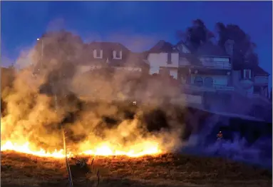  ?? RECORDER PHOTOS BY CHIEKO HARA ?? Firefighte­rs put out a grass fire near Highland Drive Wednesday, June 27. Portervill­e Fire Department said the fire was caused by illegal fireworks.