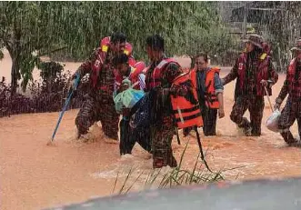 ?? (Foto Facebook Bomba Johor) ?? Pasukan bomba membantu penduduk berpindah susulan banjir yang semakin memburuk di Kampung Sentosa Damai, Pasir Gudang pagi semalam.